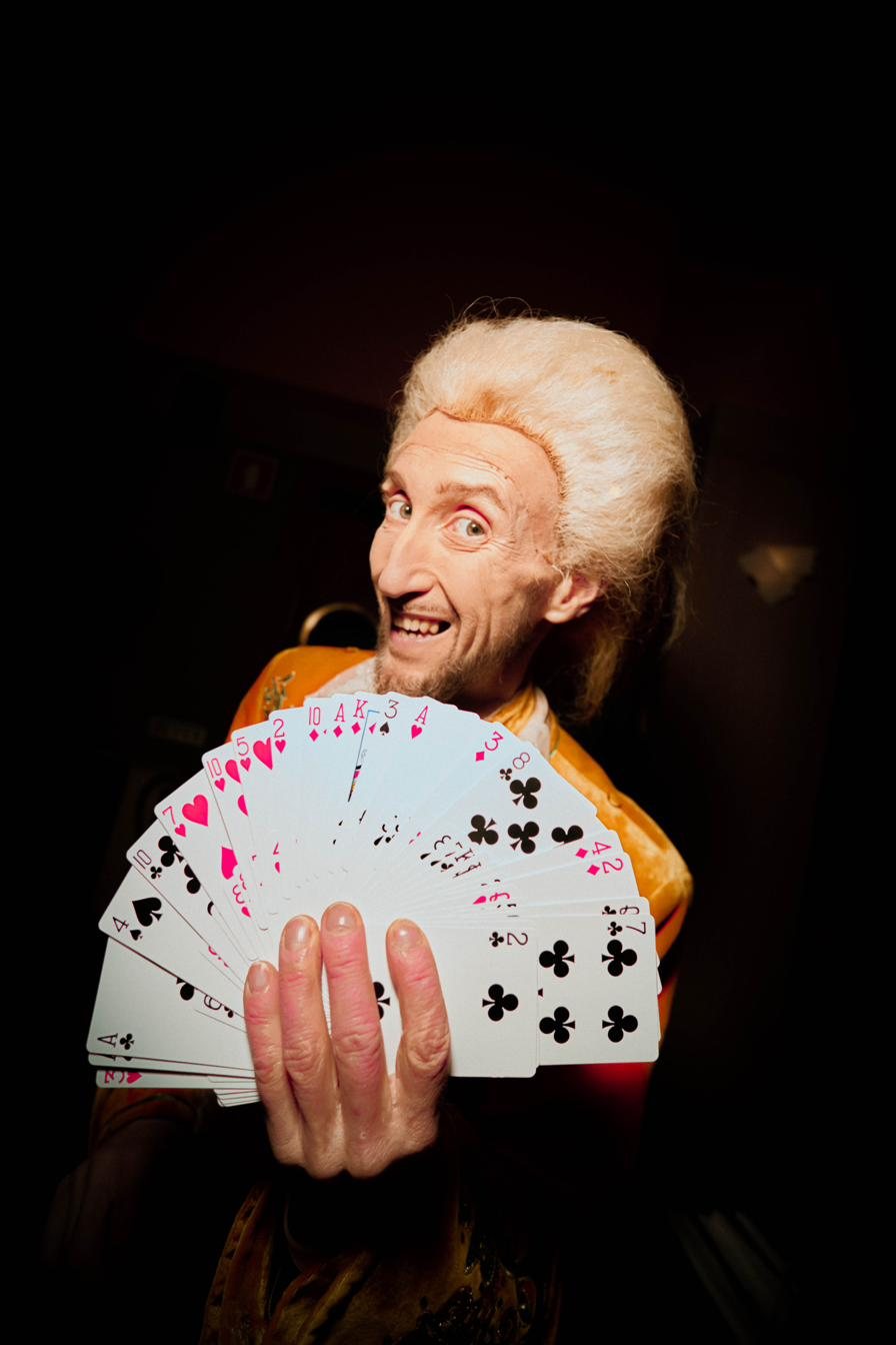Mágico com leque de cartas entre as mesas do GIO